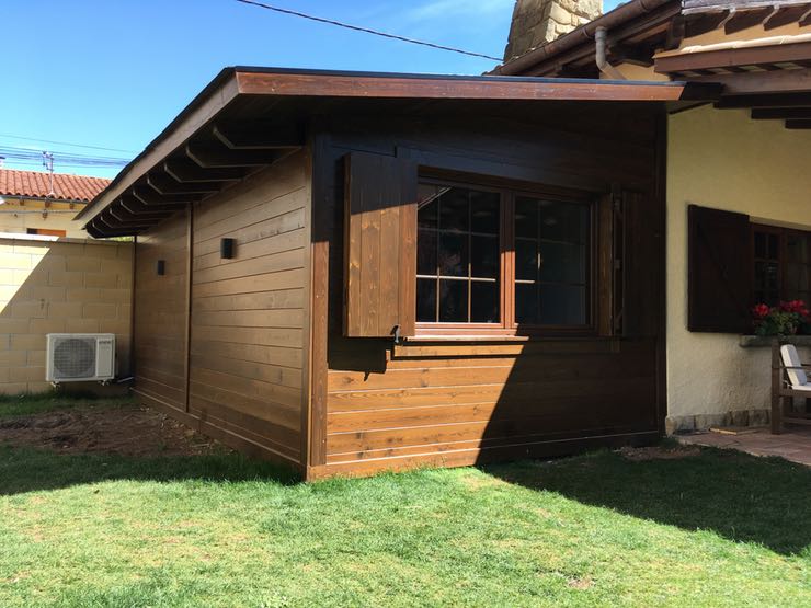 Ampliació de vivenda feta amb fusta rústica. Finestra de pvc amb porticons exteriors de fusta
